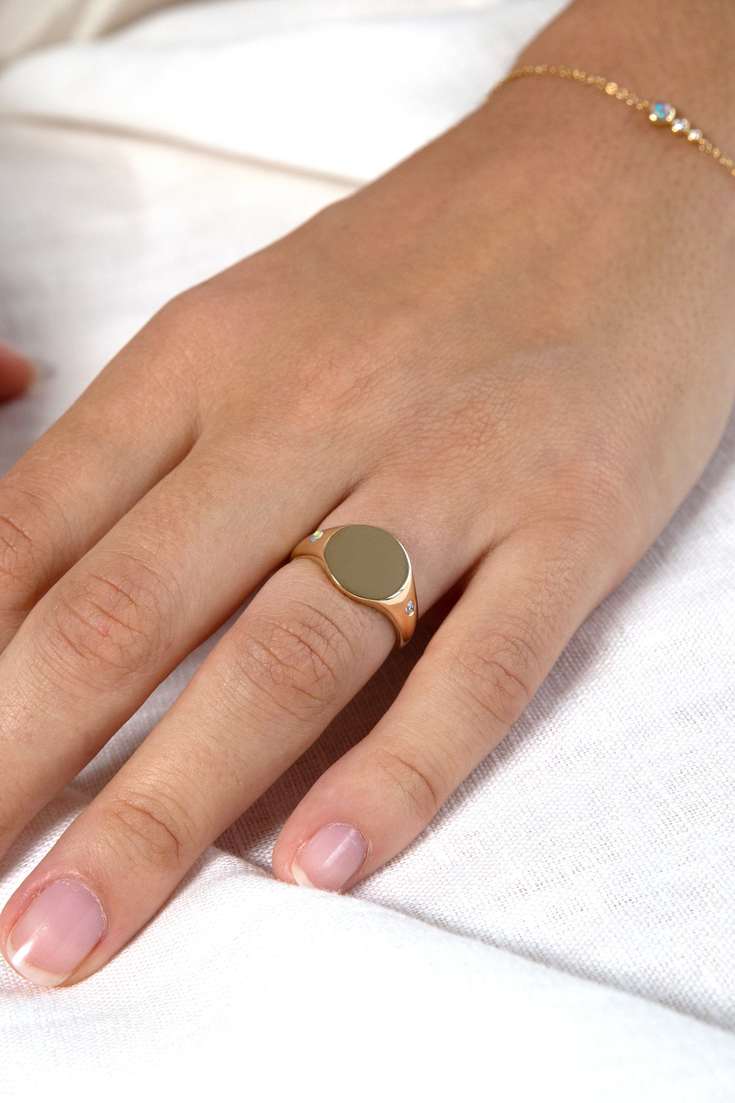Hand wearing a gold ring on a white background