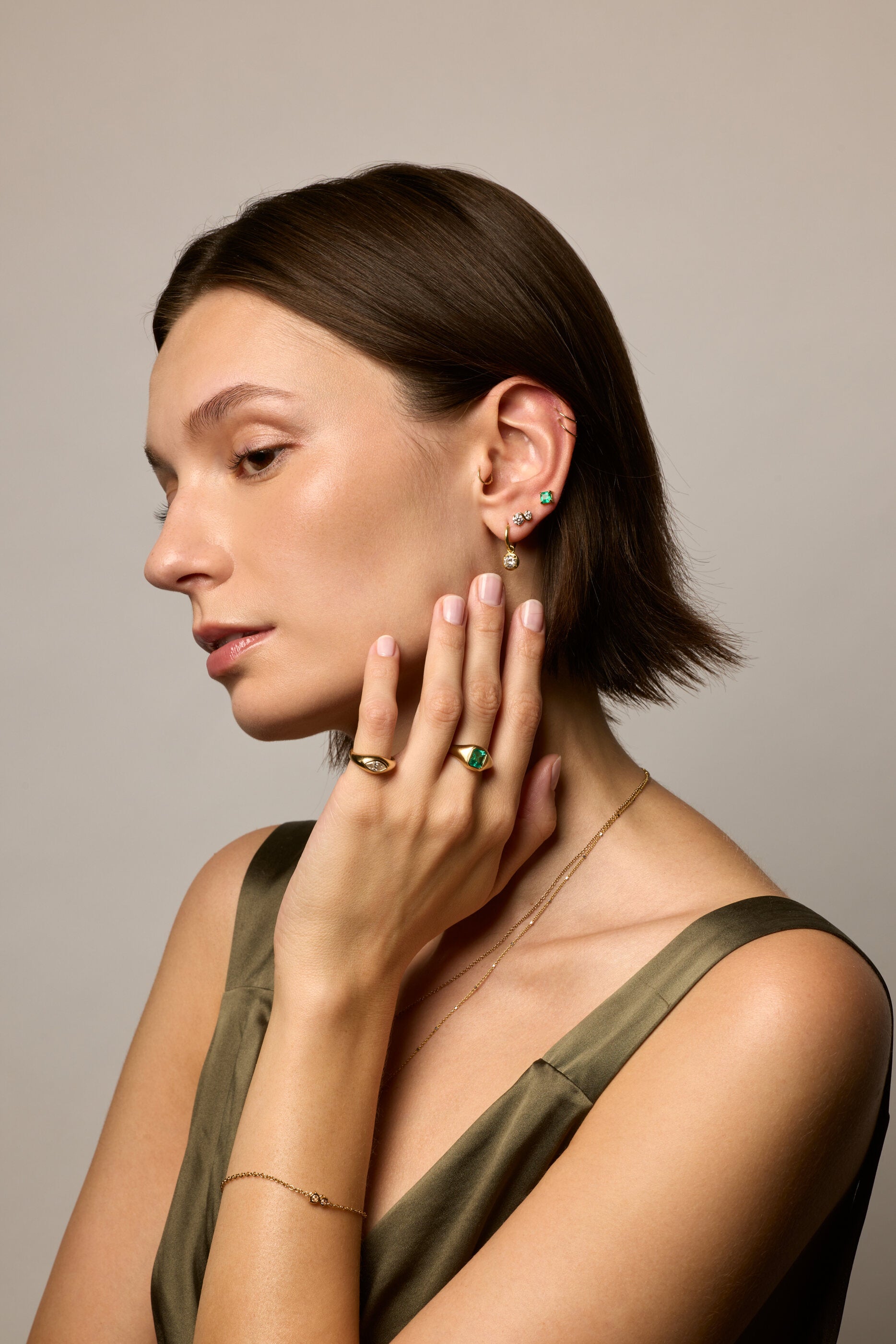 Model wearing rings and earrings in yellow gold